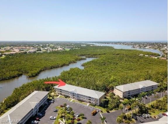 3041 Sandpiper Bay Circle, Unit H203 Naples, FL 34112 - Photo 1 of 23 an aerial view of lake and residential houses with outdoor space