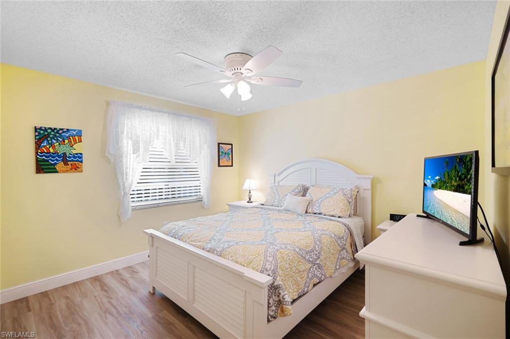3041 Sandpiper Bay Circle, Unit H203 Naples, FL 34112 - Photo 14 of 23 a bedroom with a bed and a window