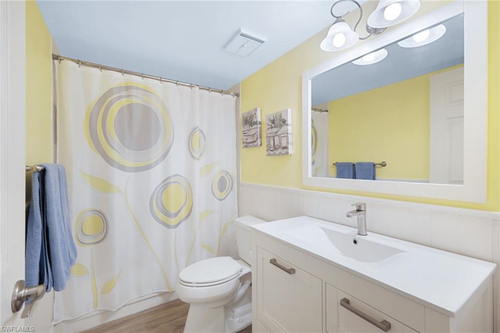 3041 Sandpiper Bay Circle, Unit H203 Naples, FL 34112 - Photo 15 of 23 a bathroom with a sink vanity mirror and toilet