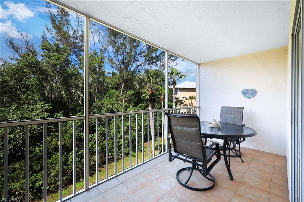 3041 Sandpiper Bay Circle, Unit H203 Naples, FL 34112 - Photo 16 of 23 a view of a chair and table in the balcony