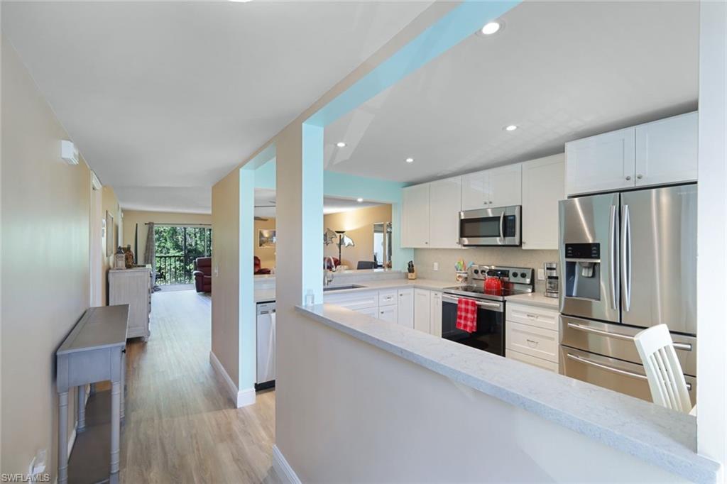 3041 Sandpiper Bay Circle, Unit H203 Naples, FL 34112 - Photo 5 of 23 a kitchen with cabinets and stainless steel appliances