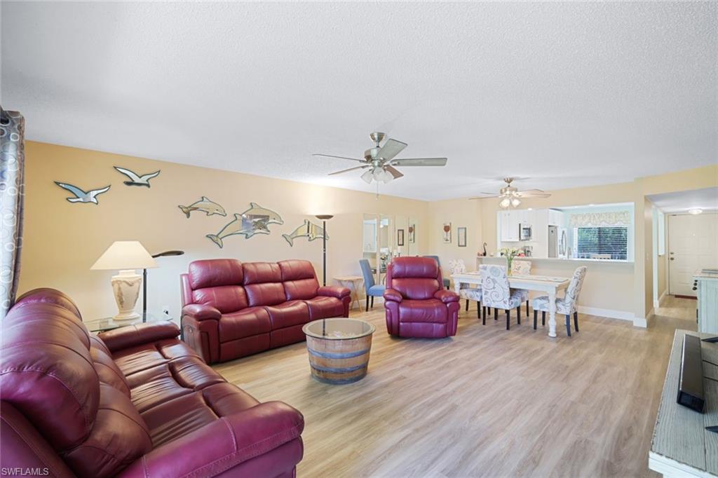3041 Sandpiper Bay Circle, Unit H203 Naples, FL 34112 - Photo 7 of 23 a living room with furniture a couch and a chandelier