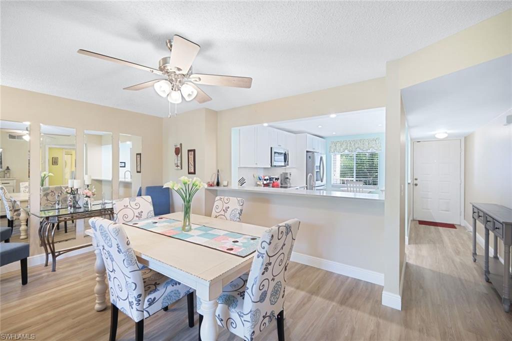3041 Sandpiper Bay Circle, Unit H203 Naples, FL 34112 - Photo 10 of 23 a view of a dining room with furniture window and wooden floor
