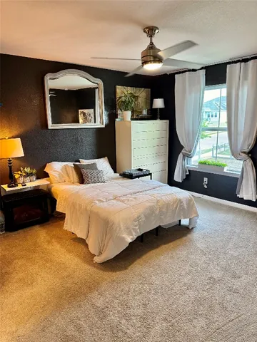 a bedroom with a bed mirror and window