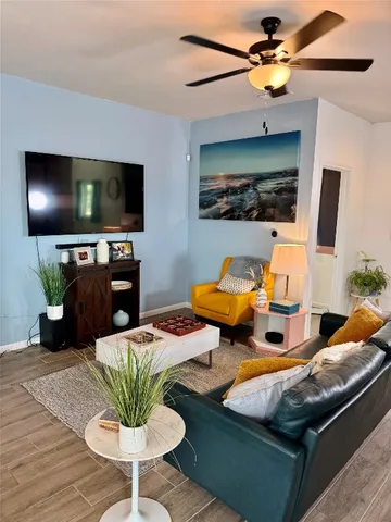 a living room with furniture kitchen view and a flat screen tv