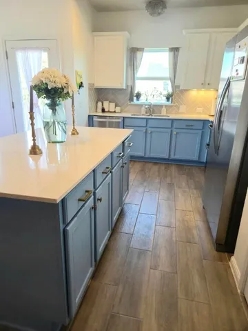 a large kitchen with granite countertop a sink counter space and cabinets