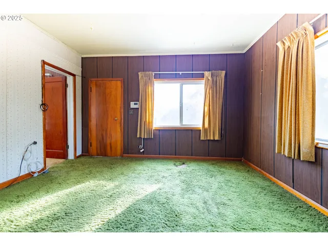 a view of front door with yard and balcony