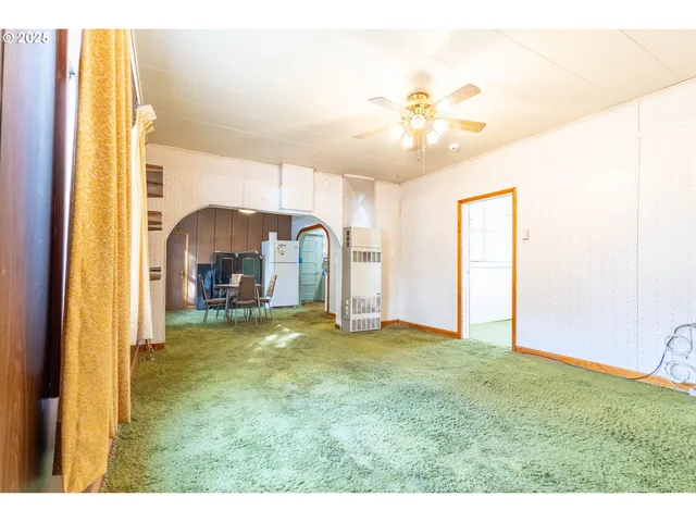 a view of living room with hardwood floor and ceiling fan
