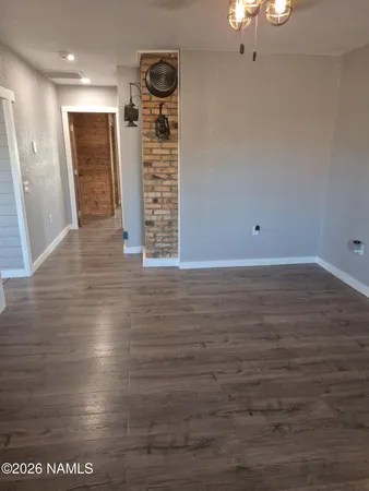 a view of an empty room with wooden floor