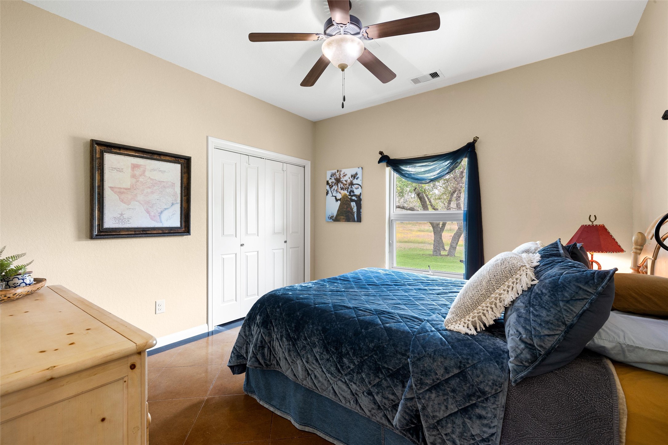 426 Preiss Ranch Road Blanco, TX 78606 - Photo 23 of 40 a bedroom with a bed and a chandelier