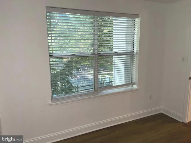 a view of a small space with wooden floor and a window