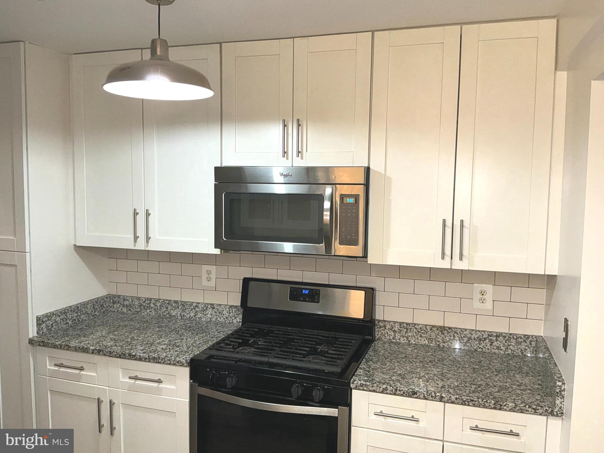 10003 Vanderbilt Circle, Unit 11 Rockville, MD 20850 - Photo 4 of 23 a kitchen with stainless steel appliances granite countertop a sink a stove and a microwave