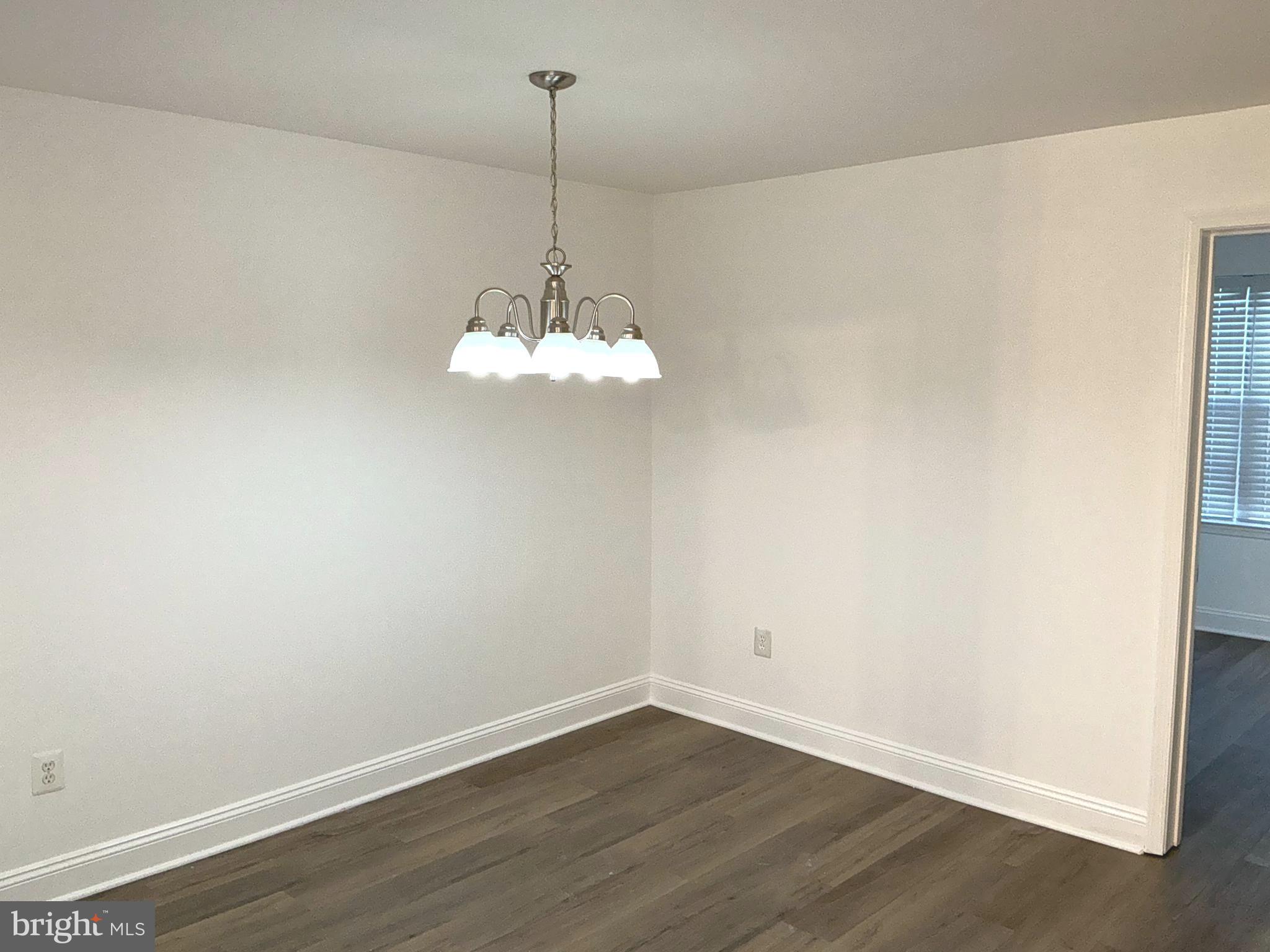 10003 Vanderbilt Circle, Unit 11 Rockville, MD 20850 - Photo 8 of 23 a view of empty room with wooden floor chandelier