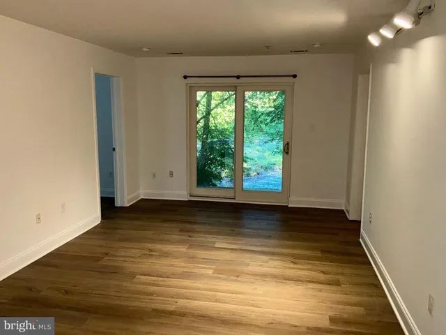 a view of a small space with wooden floor and a window