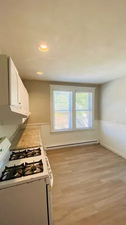 a view of a kitchen with a stove wooden floor and a window