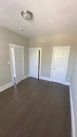 an empty room with windows and closet