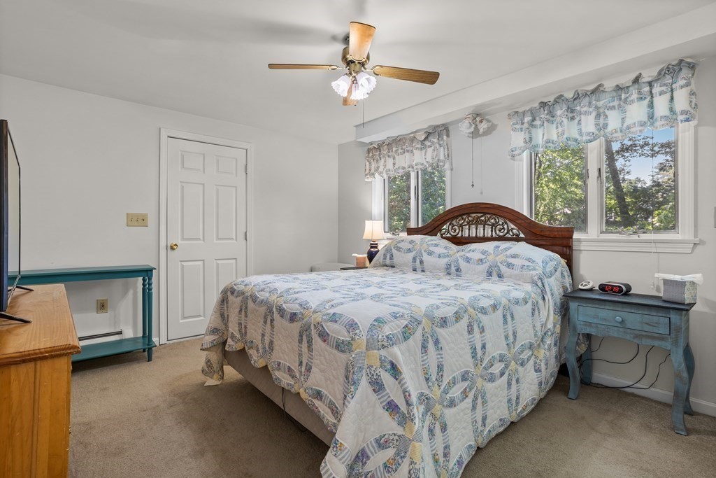 56 Lake Shore Road Salem, NH 03079 - Photo 12 of 39 a bedroom with a bed and a chandelier