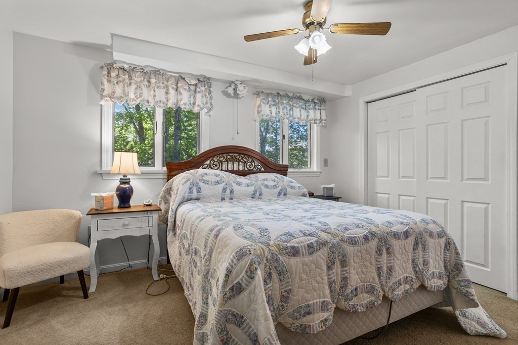 56 Lake Shore Road Salem, NH 03079 - Photo 13 of 39 a bedroom with a bed and a chandelier