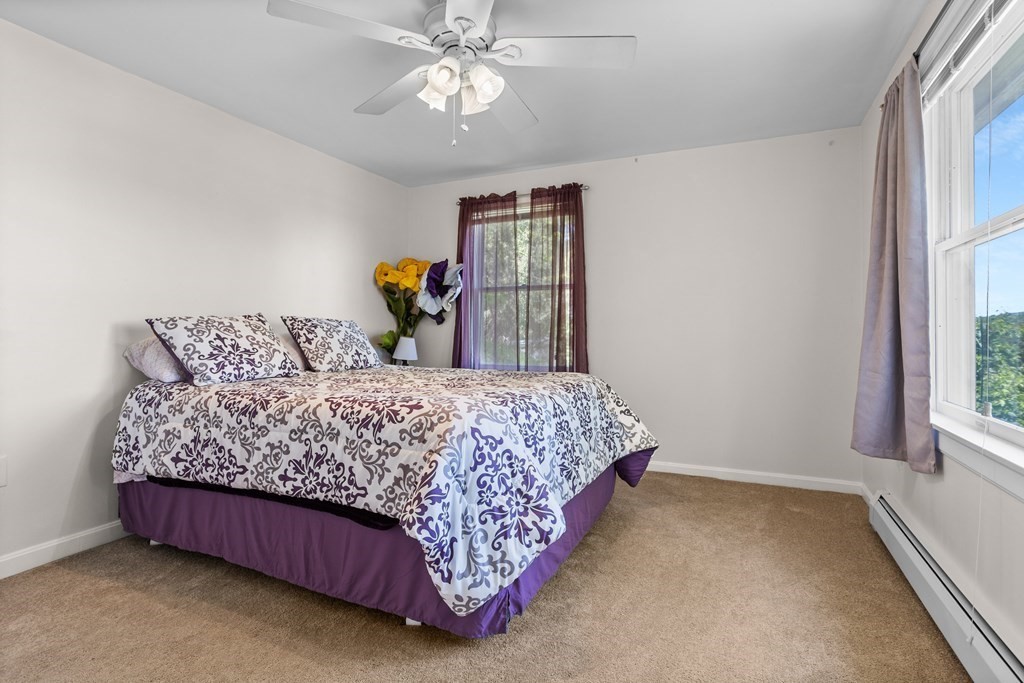 56 Lake Shore Road Salem, NH 03079 - Photo 21 of 39 a bedroom with a large bed and a chandelier