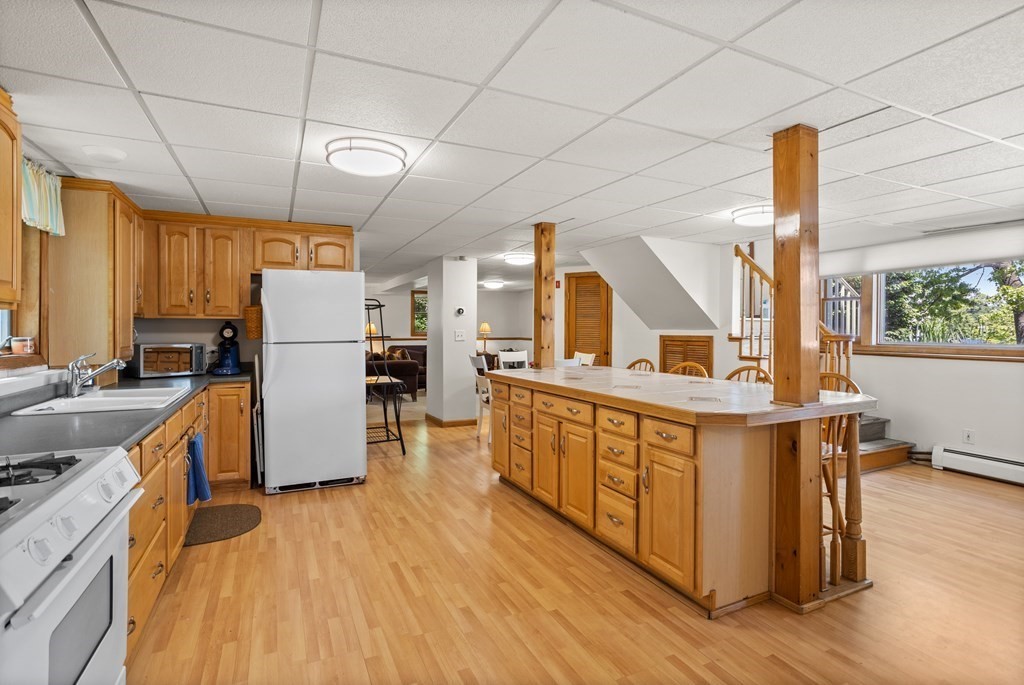56 Lake Shore Road Salem, NH 03079 - Photo 23 of 39 a kitchen with stainless steel appliances granite countertop a refrigerator a stove a sink dishwasher and wooden cabinets with wooden floor
