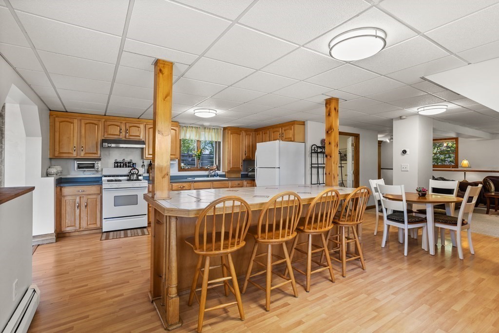 56 Lake Shore Road Salem, NH 03079 - Photo 24 of 39 a kitchen with stainless steel appliances a dining table chairs and wooden floor