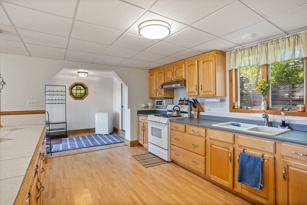 56 Lake Shore Road Salem, NH 03079 - Photo 26 of 39 a open kitchen with stainless steel appliances granite countertop a stove a sink dishwasher and white cabinets with wooden floor