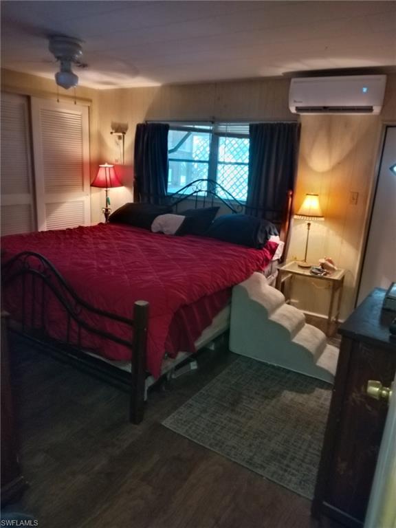 519 Riviera Boulevard East Naples, FL 34112 - Photo 15 of 23 Bedroom with wood finished floors and a wall mounted air conditioner