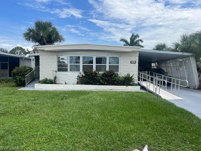 519 Riviera Boulevard East Naples, FL 34112 - Photo 2 of 23 Manufactured / mobile home with a carport, a front lawn, driveway, and brick siding