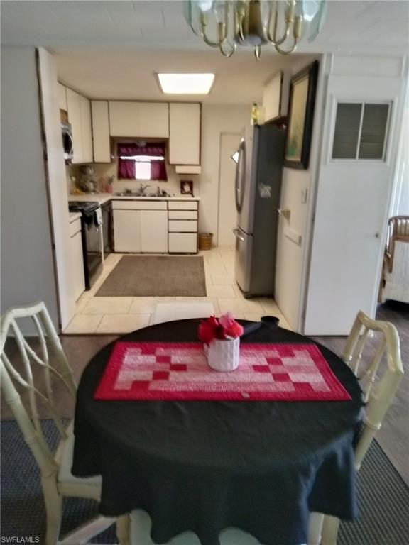 519 Riviera Boulevard East Naples, FL 34112 - Photo 7 of 23 Dining area with a chandelier and light tile patterned floors