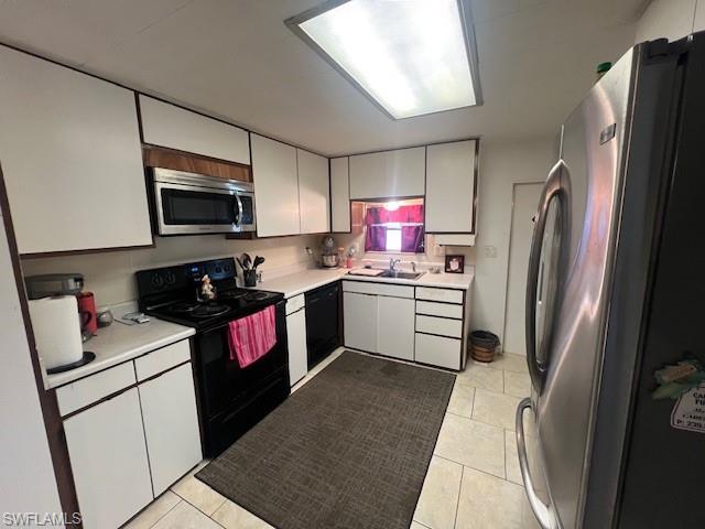 519 Riviera Boulevard East Naples, FL 34112 - Photo 8 of 23 Kitchen with black appliances, light countertops, and light tile patterned floors