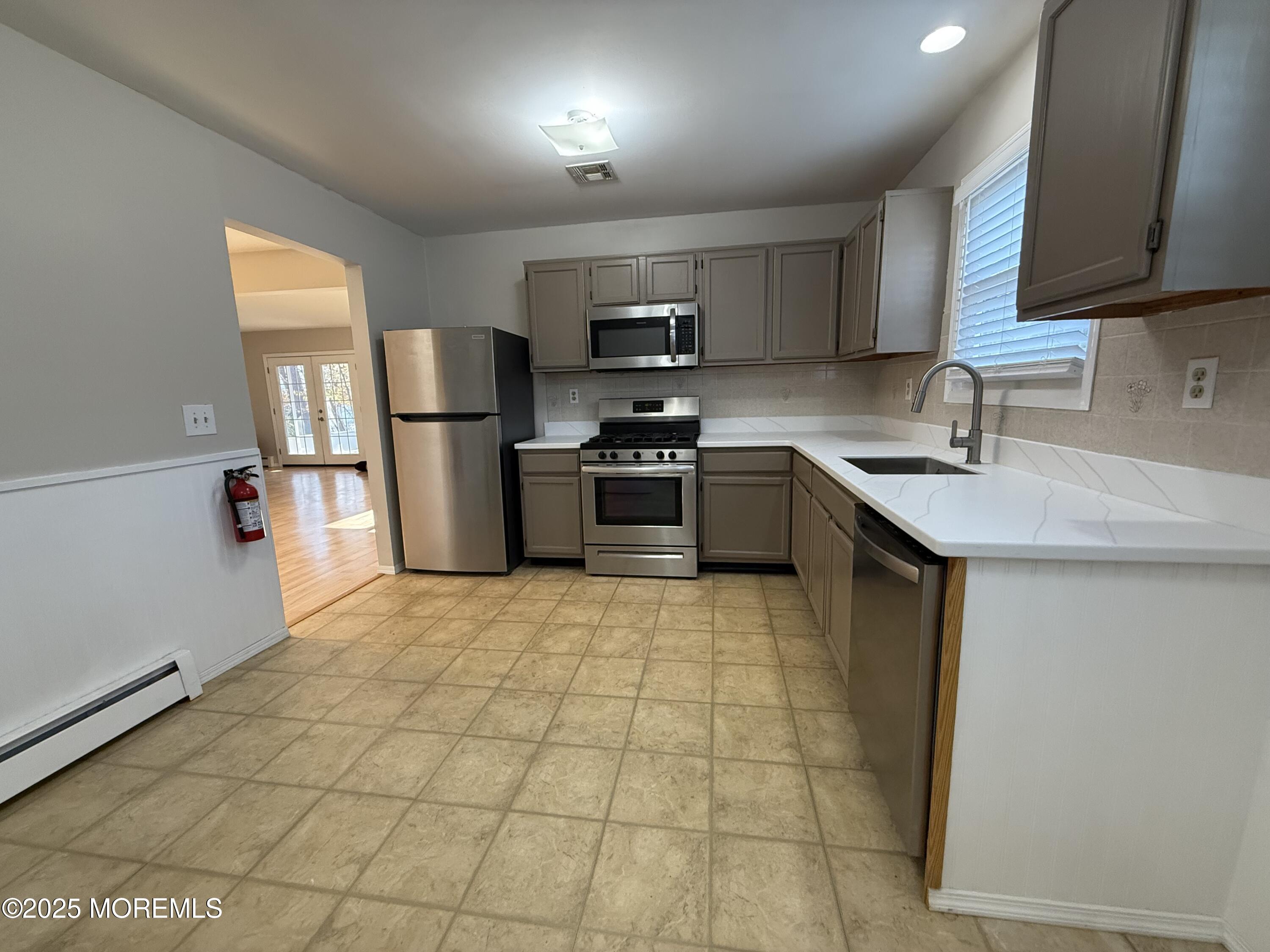 68 Virgin Islands Drive Toms River, NJ 08757 - Photo 15 of 19 a kitchen with a sink a stove top oven a refrigerator and grey cabinets