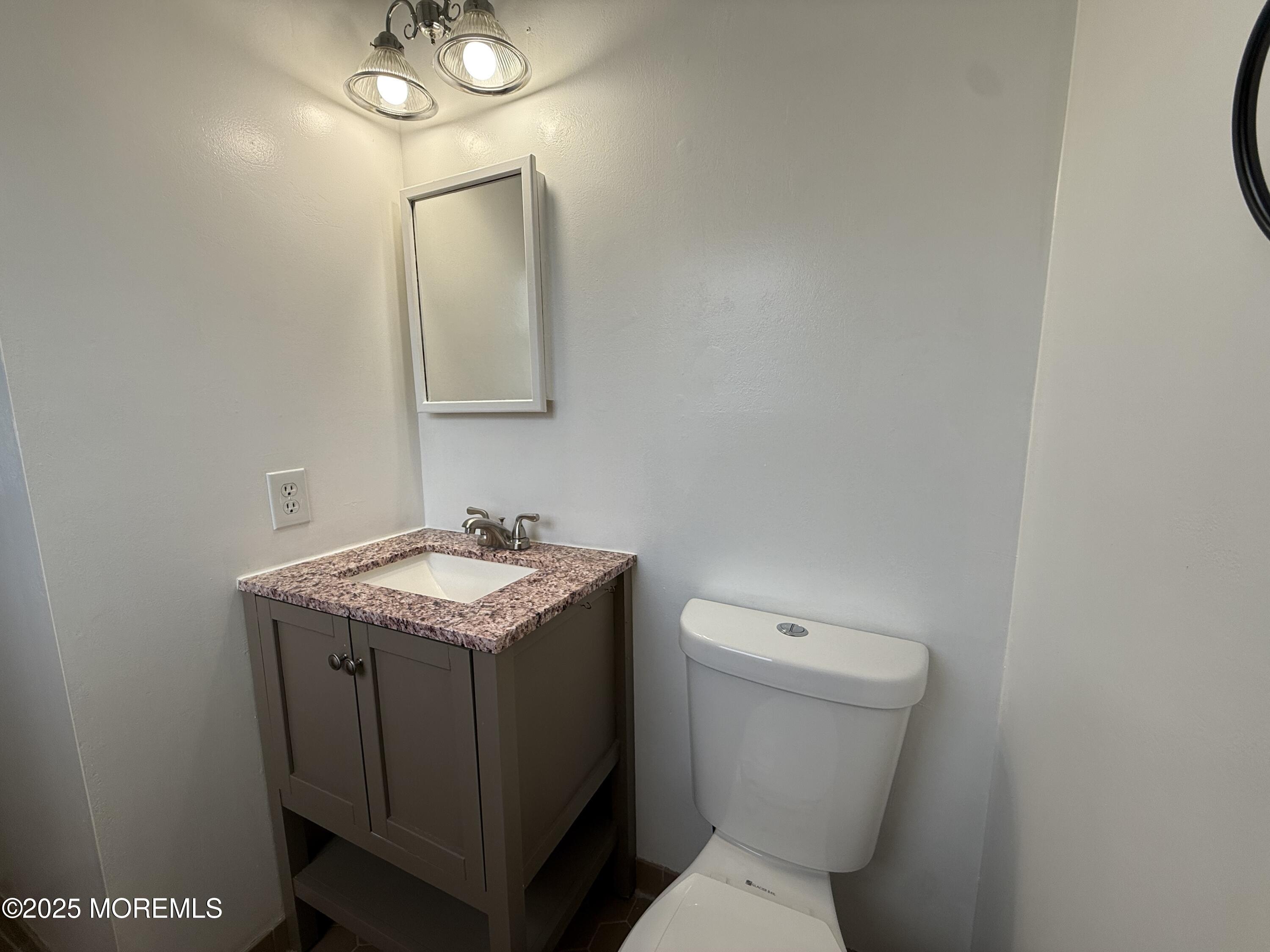 68 Virgin Islands Drive Toms River, NJ 08757 - Photo 17 of 19 a bathroom with a granite countertop toilet a sink and mirror