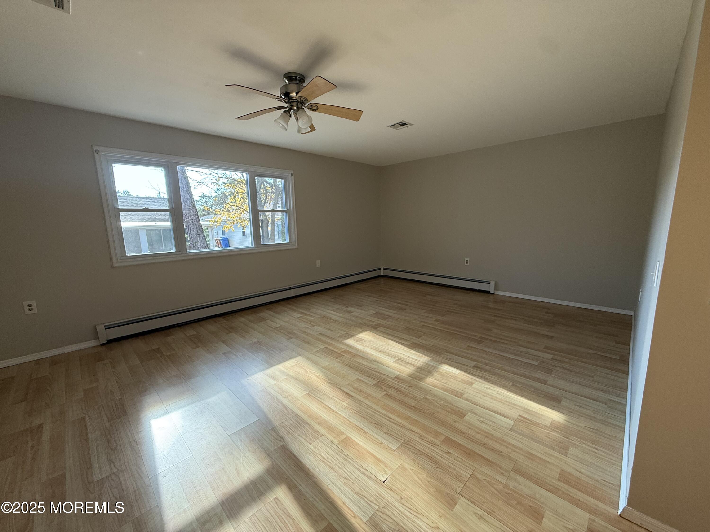 68 Virgin Islands Drive Toms River, NJ 08757 - Photo 7 of 19 an empty room with wooden floor fan and windows