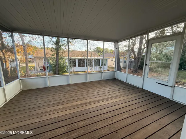 a view of a room with wooden floor and windows