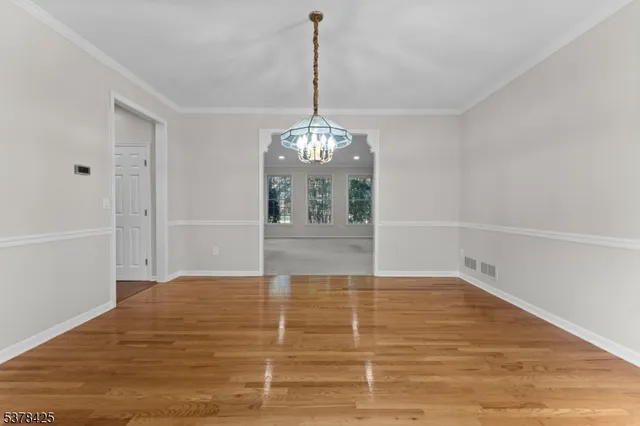 a view of a room with wooden floor and chandelier