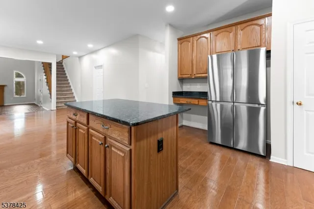 a kitchen with stainless steel appliances granite countertop a refrigerator a sink and a stove