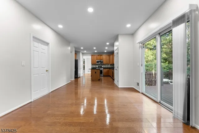 a view of a living room and a kitchen with wooden floor