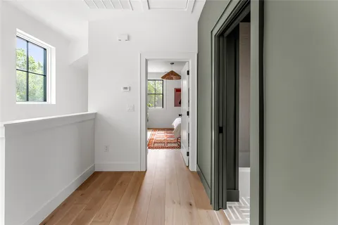 a view of a hallway with wooden floor and a living room