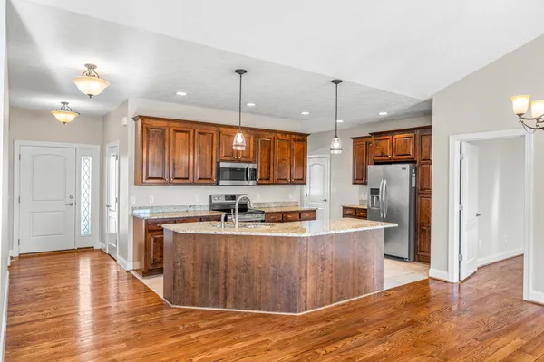 a kitchen with stainless steel appliances granite countertop a sink refrigerator and cabinets