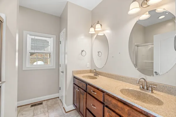 a bathroom with a granite countertop sink and a mirror