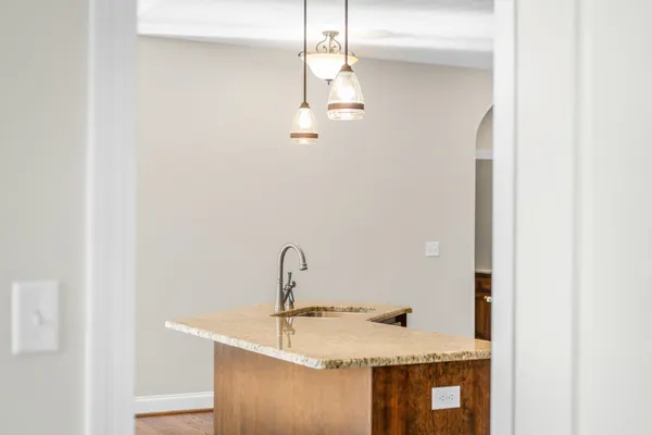 a bathroom with a granite countertop sink a toilet a mirror and shower
