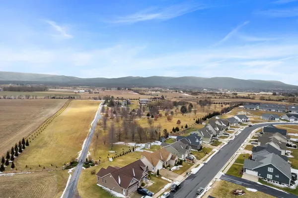 a view of a big house with wooden fence