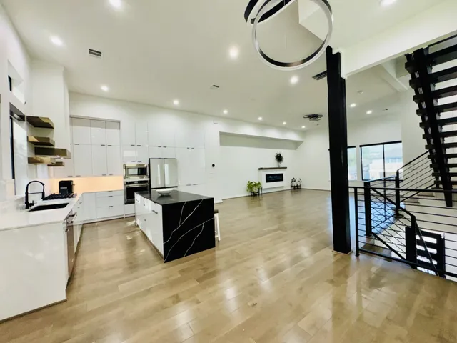 a large living room with stainless steel appliances kitchen island granite countertop a large counter top stainless steel appliances and cabinets