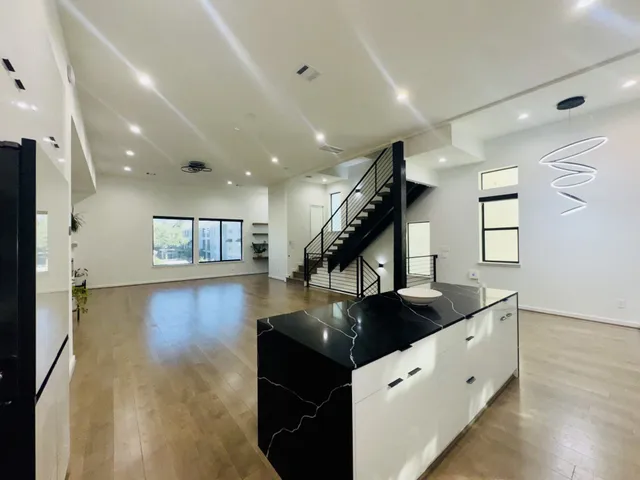 a kitchen with stainless steel appliances granite countertop a sink a stove and a wooden floors