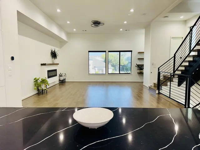 a room with wooden floor pool table and windows