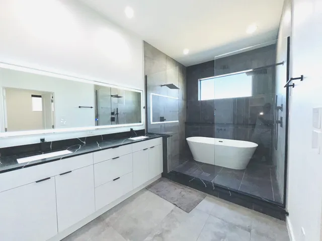 a bathroom with a double vanity sink a mirror and a bathtub