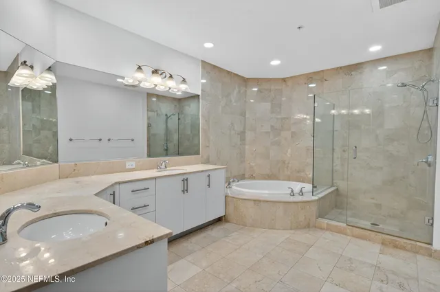 a large bathroom with a tub a double vanity sink and a mirror