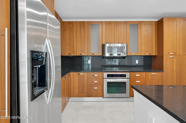 a kitchen with stainless steel appliances granite countertop a stove and a refrigerator