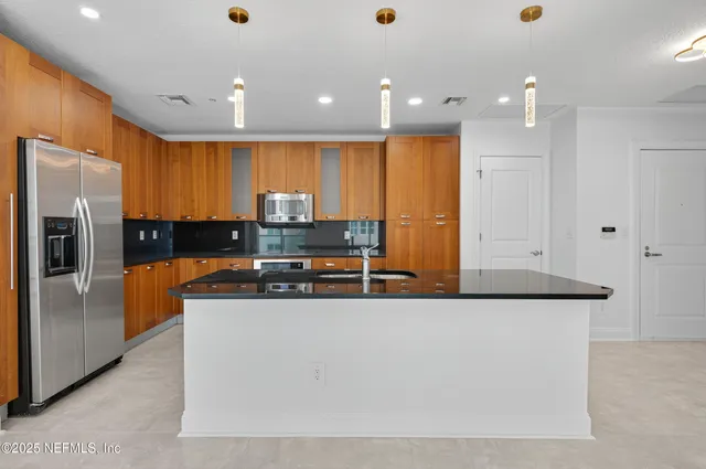 a view of a kitchen with a refrigerator a microwave and a sink