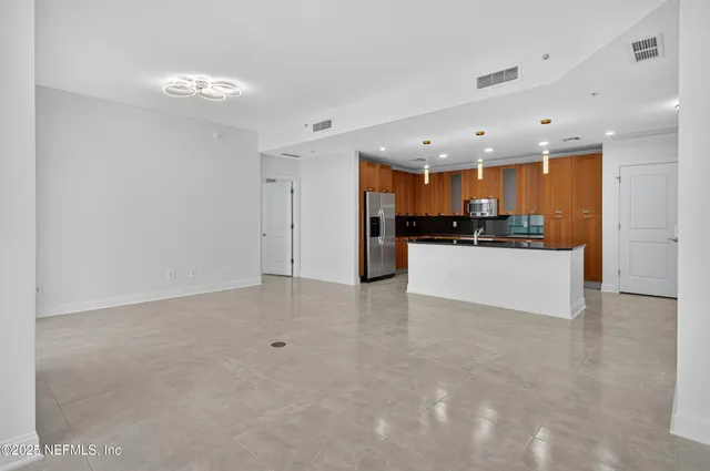 a view of kitchen with kitchen island a sink stainless steel appliances and cabinets